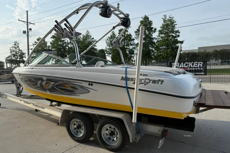 Slide: The Image of 2005 MasterCraft X10 boat on trailer, featuring sleek design and vibrant yellow accents. - 6