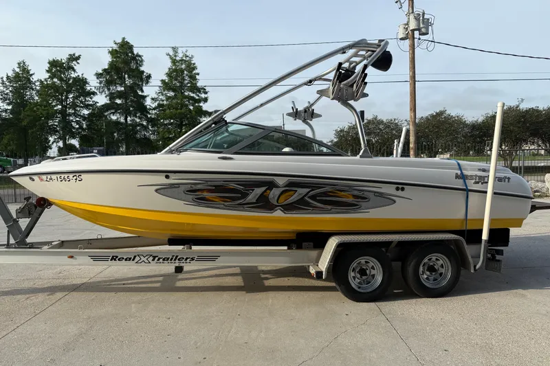 Slide: The Image of 2005 MasterCraft X10 boat on trailer, yellow and white design, parked outdoors. - 7