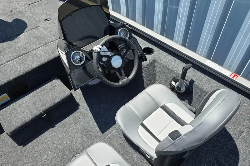 Slide: The Image of 2026 Lowe Stinger 175 boat interior with steering wheel and seating. - 2