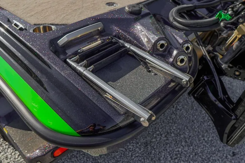 Slide: The Image of 2023 Bass Cat Puma STS boat with metallic finish and green accents, featuring a retractable ladder. - 29