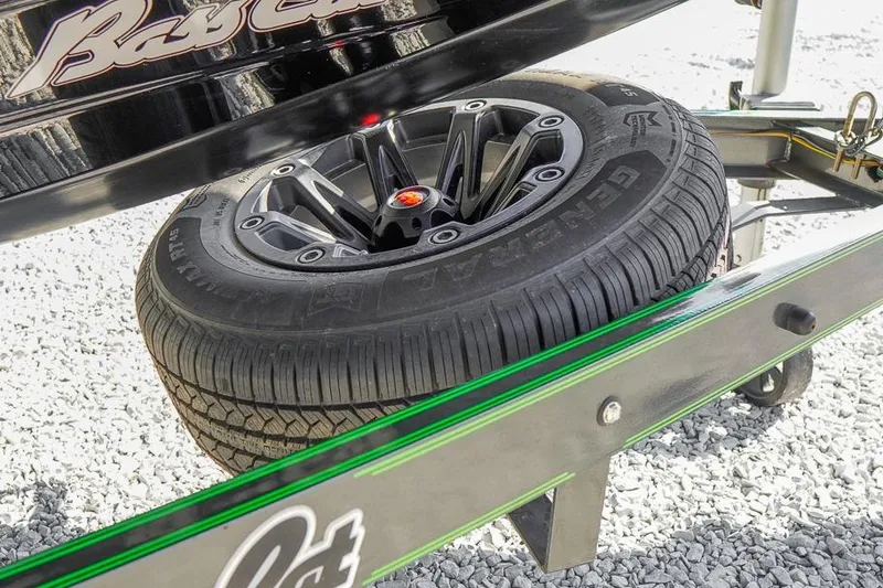Slide: The Image of 2023 Bass Cat Puma STS trailer tire on gravel, showcasing sleek black rim design. - 30