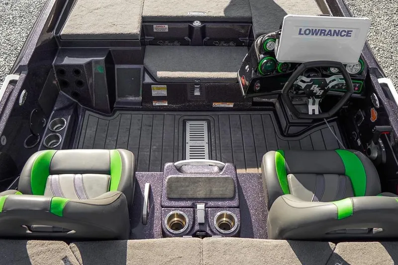 Slide: The Image of 2023 Bass Cat Puma STS boat interior with green-accented seats and Lowrance electronics. - 6
