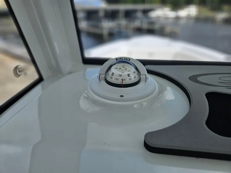 Slide: The Image of Compass on 2025 Sea Hunt Ultra 235 SE boat dashboard, near marina. - 13
