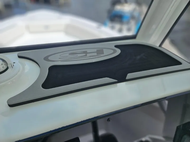 Slide: The Image of 2025 Sea Hunt Ultra 235 SE dashboard with compass and logo detail. - 14