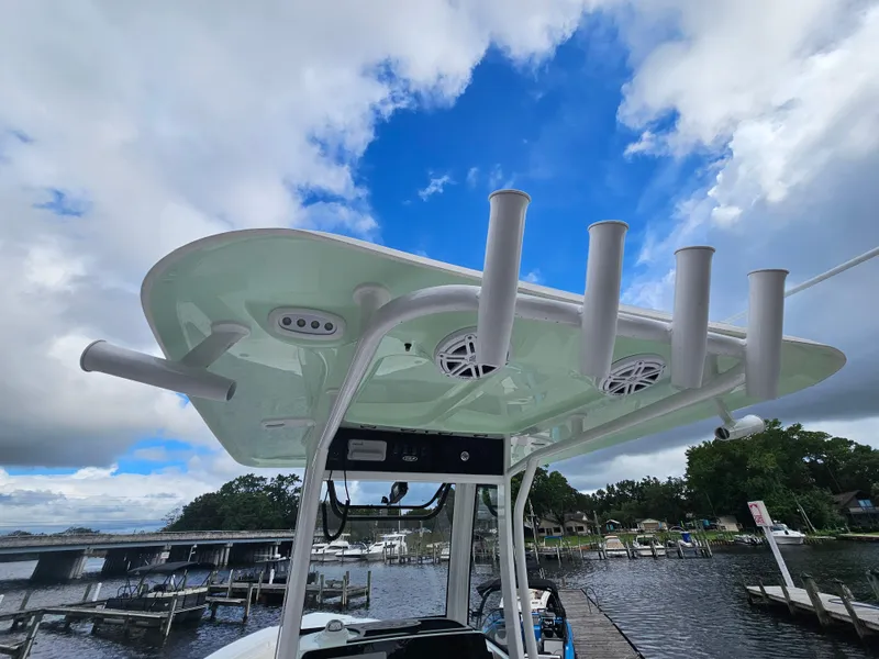 Slide: The Image of 2025 Sea Hunt Ultra 235 SE boat with rod holders and speakers, docked under a cloudy sky. - 26