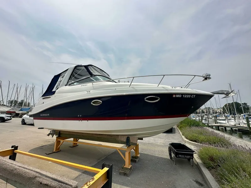Slide: The Image of 2018 Rinker EX 270 boat on display at a marina, surrounded by other boats. - 18