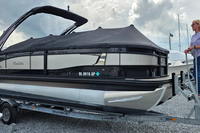 The Image of 2025 Barletta Lusso 25UCA pontoon boat on trailer, covered and ready for transport. - 0