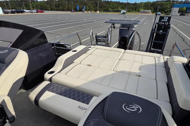 Slide: The Image of 2025 Barletta Lusso 25UCA pontoon boat with luxurious seating in a parking lot. - 15