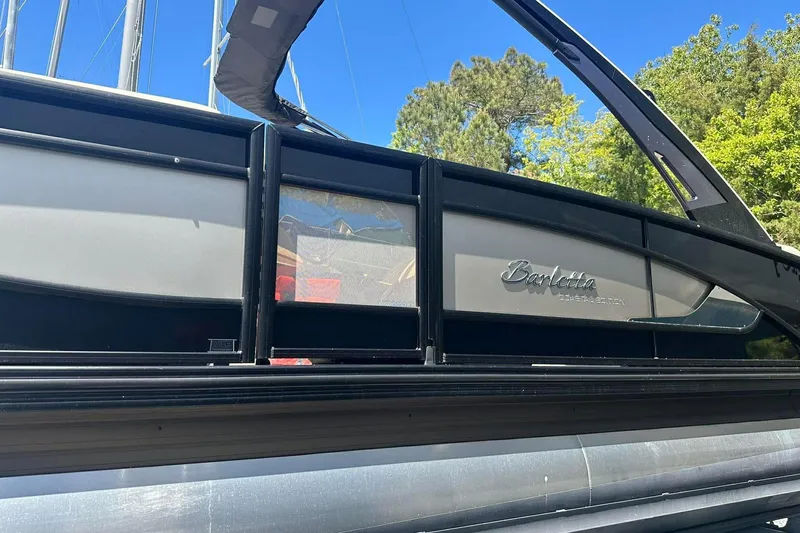 Slide: The Image of 2025 Barletta Lusso 25UCA pontoon boat side view with sleek design and logo. - 28