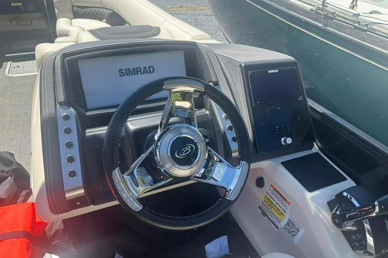 Slide: The Image of 2025 Barletta Lusso 25UCA boat dashboard with Simrad navigation system and steering wheel. - 4