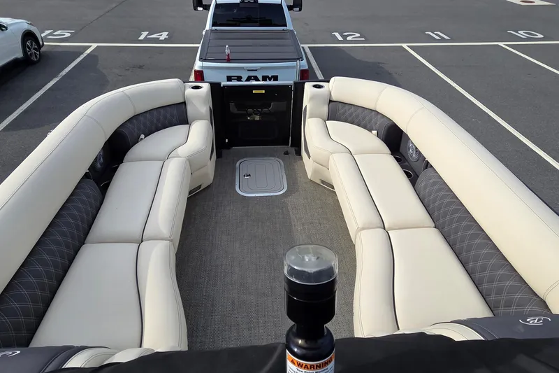 Slide: The Image of 2025 Barletta Lusso 25UCA pontoon boat interior with luxurious seating in a parking lot. - 7