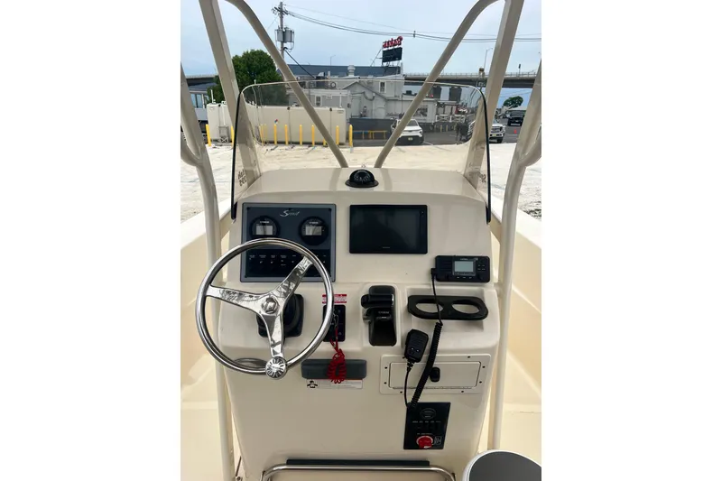 Slide: The Image of 2020 Scout 195 Sportfish boat dashboard with steering wheel and navigation controls. - 10