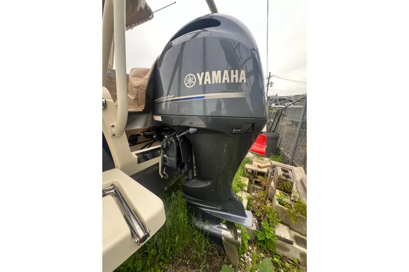 Slide: The Image of 2020 Scout 195 Sportfish with Yamaha outboard motor, parked outdoors. - 15
