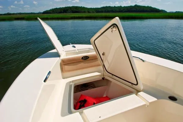 Slide: The Image of Manufacturer Provided Image: 2020 Scout 195 Sportfish boat with open storage compartments on calm water. - 4
