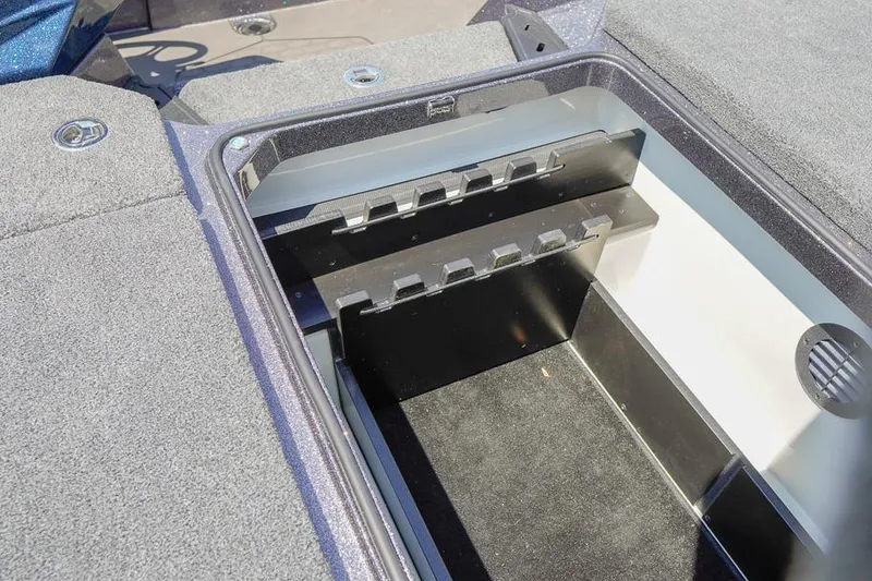 Slide: The Image of 2025 Ranger Z520 boat storage compartment with rod holders and carpeted interior. - 20