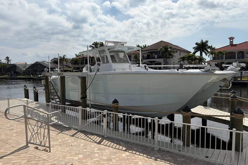 The Image of 2019 Invincible 40 Catamaran docked at a marina with waterfront homes in the background. - 0