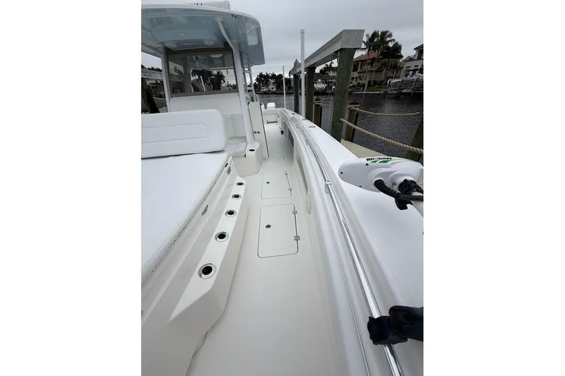 Slide: The Image of 2019 Invincible 40 Catamaran docked, showcasing sleek deck design and seating area. - 10