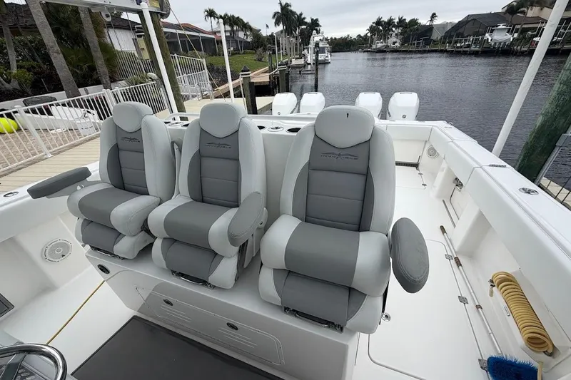 Slide: The Image of Luxurious seating on 2019 Invincible 40 Catamaran, docked by a serene waterfront. - 11
