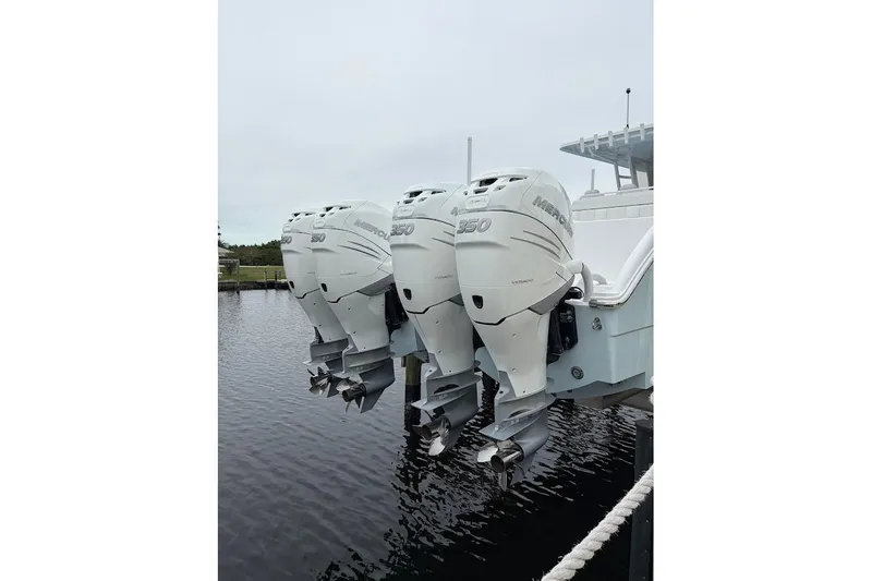 Slide: The Image of Triple Mercury 350 outboard engines on a 2019 Invincible 40 Catamaran, docked by the water. - 23