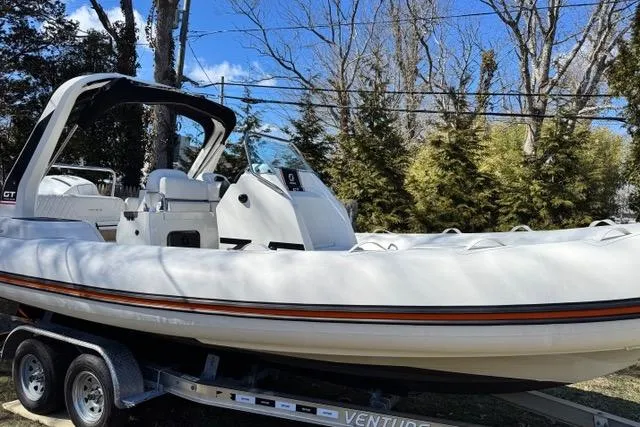 Slide: The Image of 2024 Zodiac Medline 7.5 GT boat on trailer, surrounded by trees and blue sky. - 1