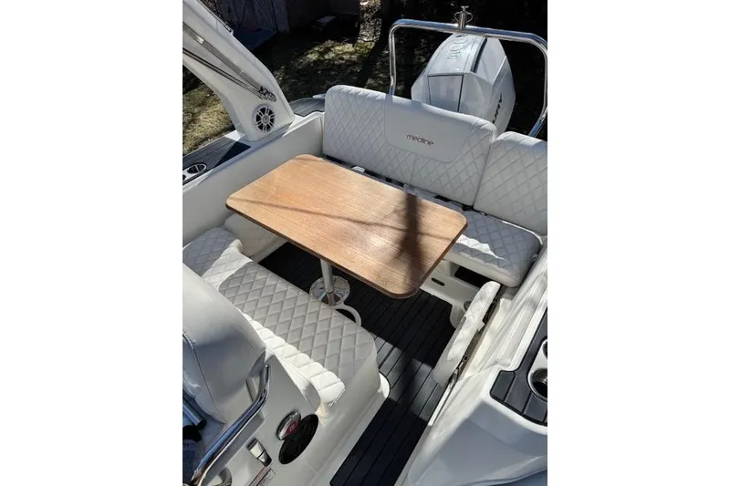 Slide: The Image of 2024 Zodiac Medline 7.5 GT boat interior with white quilted seating and wooden table. - 10