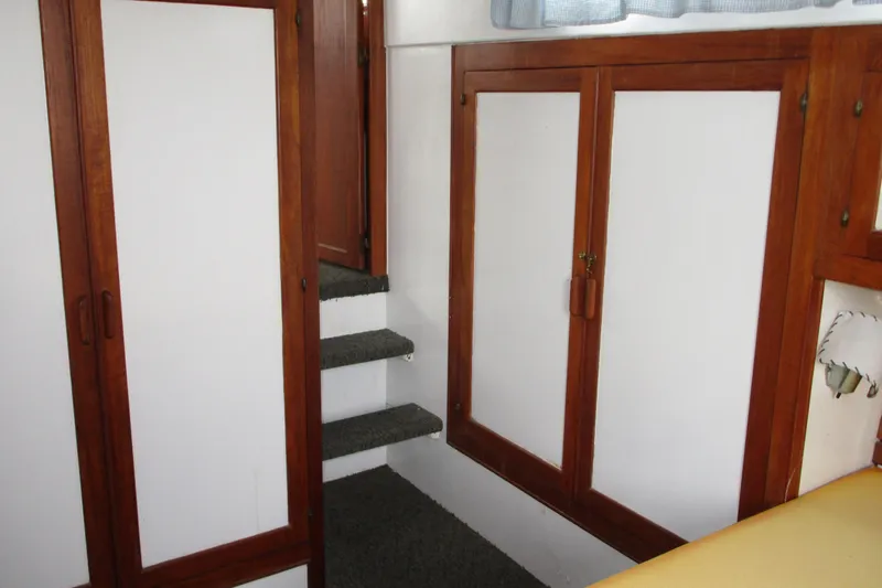 Slide: The Image of Interior of 1979 Roughwater 41 boat with wooden cabinets and carpeted stairs. - 11