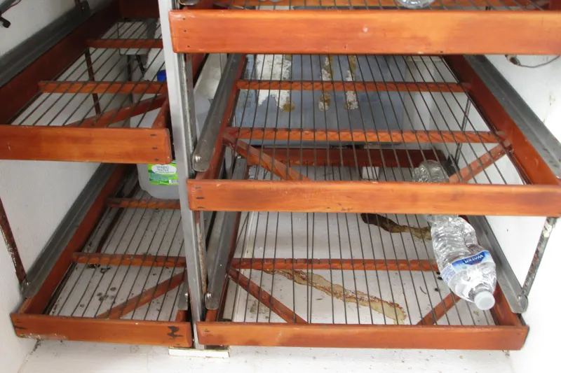 Slide: The Image of Wooden shelves with metal racks inside a 1979 Roughwater 41 boat. - 13