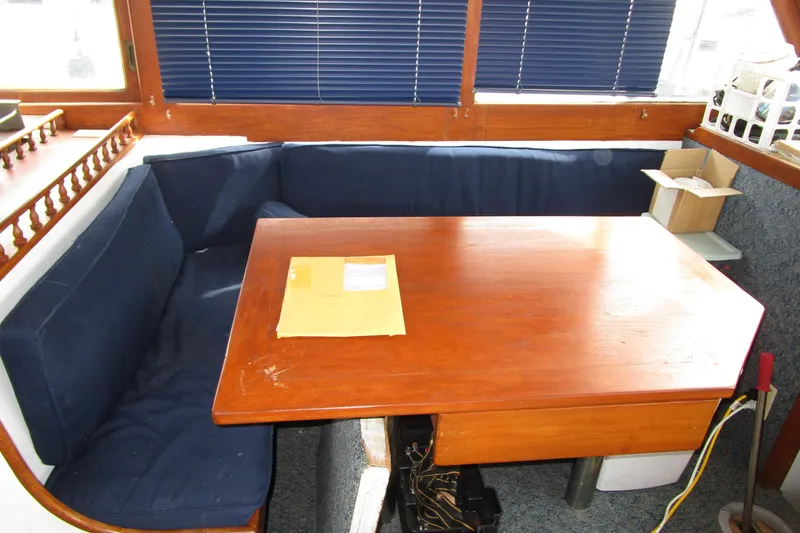 Slide: The Image of Interior of a 1979 Roughwater 41 boat with wooden table and blue seating. - 21