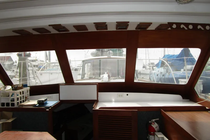 Slide: The Image of Interior view of 1979 Roughwater 41 boat with wooden accents and marina backdrop. - 22
