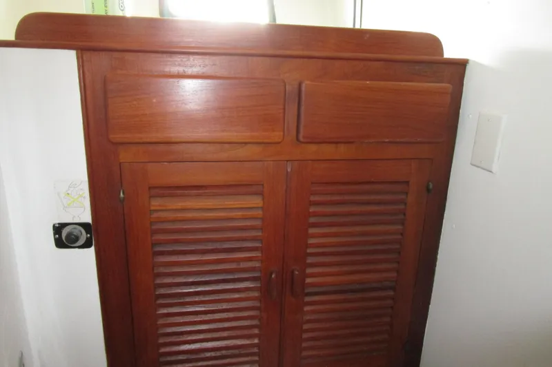 Slide: The Image of Wooden cabinet inside a 1979 Roughwater 41 boat, featuring louvered doors. - 26
