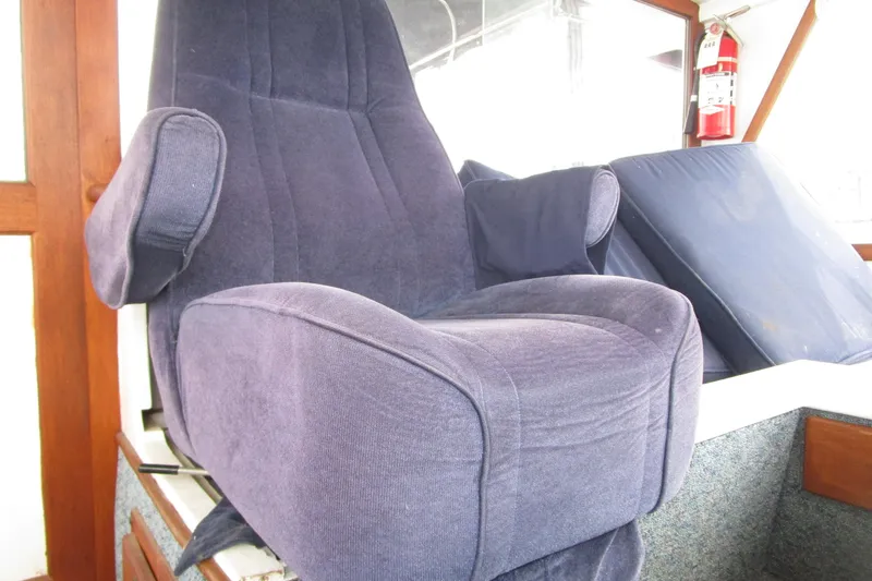 Slide: The Image of Blue captain's chair on 1979 Roughwater 41 boat, with fire extinguisher in background. - 32