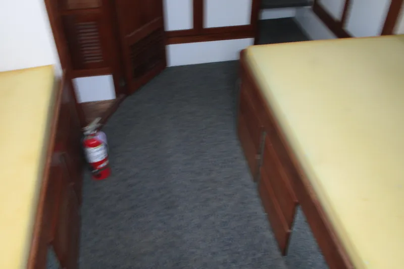Slide: The Image of Interior of 1979 Roughwater 41 boat with twin beds and fire extinguisher. - 4