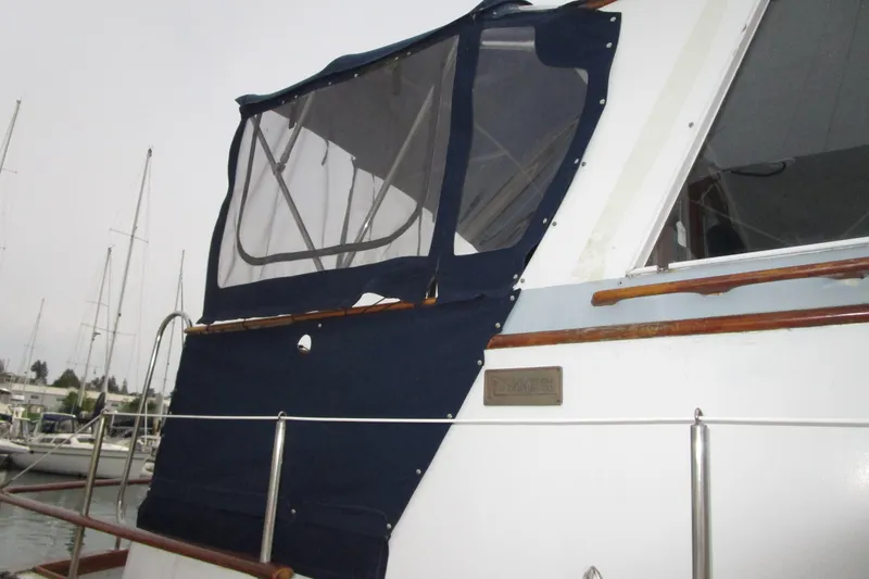 Slide: The Image of 1979 Roughwater 41 boat with blue canvas cover in marina setting. - 41