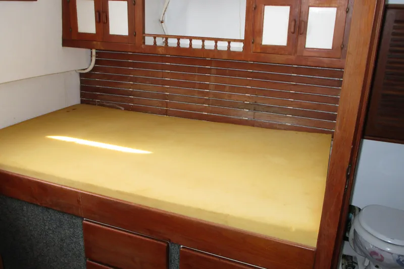 Slide: The Image of Interior of 1979 Roughwater 41 boat with wooden cabinetry and yellow mattress. - 8