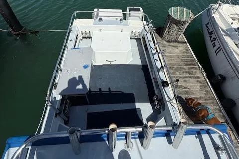 Slide: The Image of 2007 Radon Signature 26 boat docked, viewed from above, with fishing rod holders and a dog on the pier. - 14