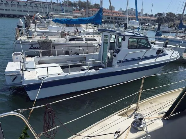 Slide: The Image of 2007 Radon Signature 26 boat docked in a marina, surrounded by other vessels. - 2