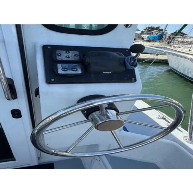 Slide: The Image of Steering wheel and controls of a 2007 Radon Signature 26 boat at a marina. - 8