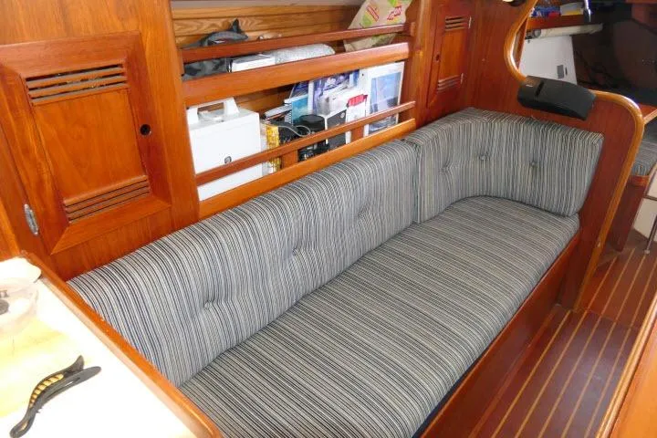 Slide: The Image of Interior of 1982 Cape Dory 36 sailboat with striped cushioned seating and wooden accents. - 10