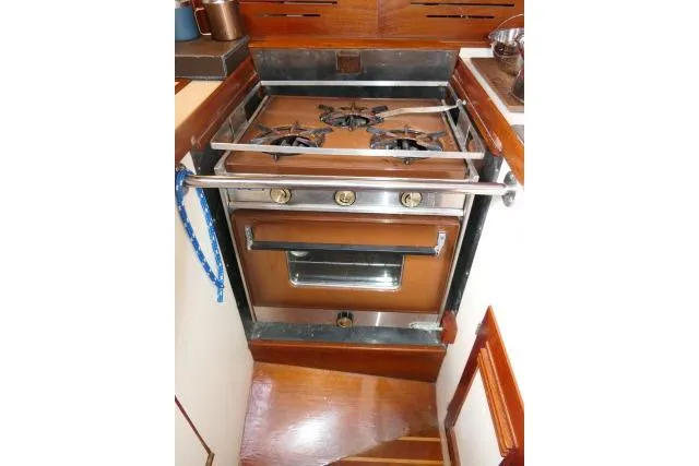 Slide: The Image of Vintage 1982 Cape Dory 36 yacht stove with wooden cabinetry and three-burner setup. - 14