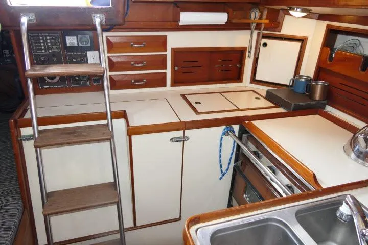 Slide: The Image of 1982 Cape Dory 36 yacht interior kitchen with wooden cabinetry and stainless steel sink. - 16