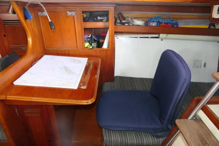 Slide: The Image of Cozy navigation station in 1982 Cape Dory 36 sailboat with chart and cushioned seat. - 19