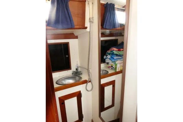 Slide: The Image of 1982 Cape Dory 36 yacht bathroom with sink, mirror, and storage shelves. - 22