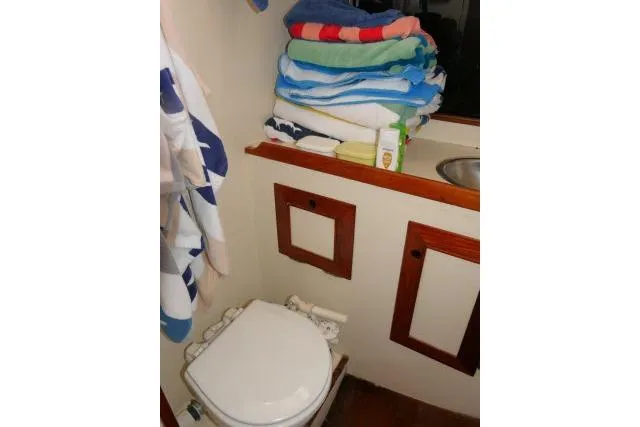 Slide: The Image of 1982 Cape Dory 36 yacht bathroom with toilet, sink, and stacked towels. - 23