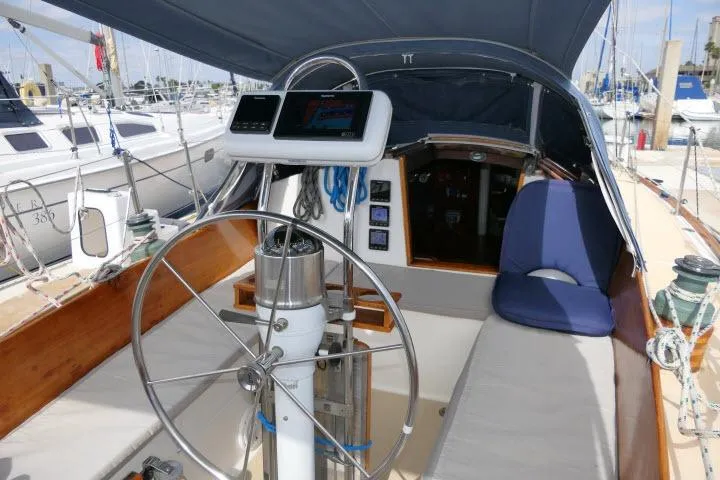 Slide: The Image of 1982 Cape Dory 36 sailboat cockpit with steering wheel and navigation equipment. - 27