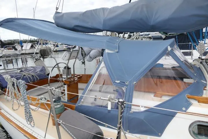Slide: The Image of 1982 Cape Dory 36 sailboat with blue canvas cover docked at marina. - 33