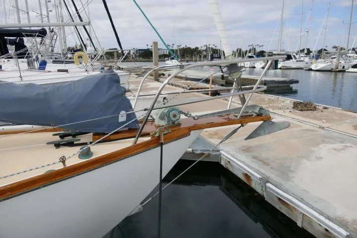 Slide: The Image of 1982 Cape Dory 36 sailboat docked at a marina, featuring a covered deck and anchor. - 38