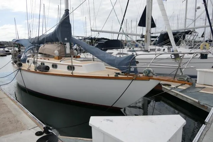 Slide: The Image of 1982 Cape Dory 36 sailboat docked at a marina, featuring classic design and blue sail cover. - 39