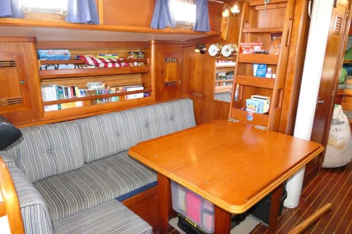 Slide: The Image of Interior of 1982 Cape Dory 36 sailboat with wooden dining area and striped seating. - 4