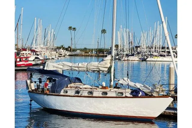 Slide: The Image of 1982 Cape Dory 36 sailboat docked in a marina with clear blue skies. - 40