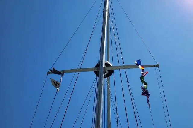Slide: The Image of Mast of 1982 Cape Dory 36 sailboat with colorful flags against clear blue sky. - 45